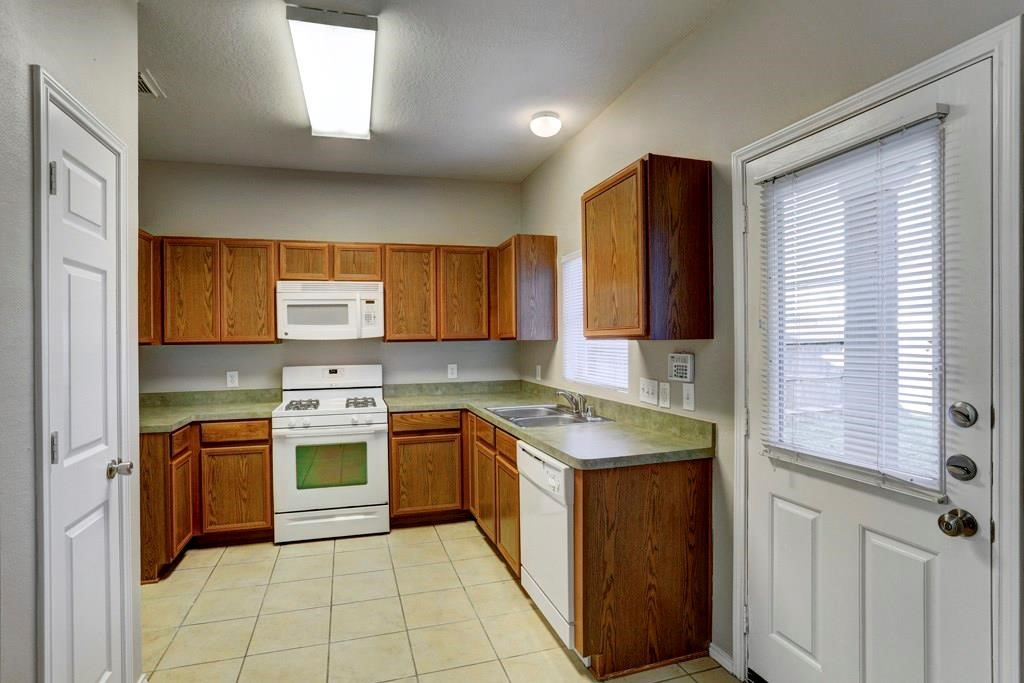 23830 Single Oak Street Spring, TX 77373 - Photo 4 of 10 a kitchen with stainless steel appliances granite countertop a sink stove and refrigerator