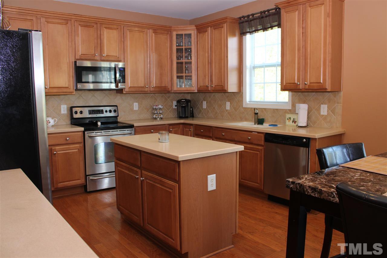 5125 Holly Ridge Farm Road Raleigh, NC 27616 - Photo 10 of 22 a kitchen with stainless steel appliances granite countertop a stove a sink and a microwave