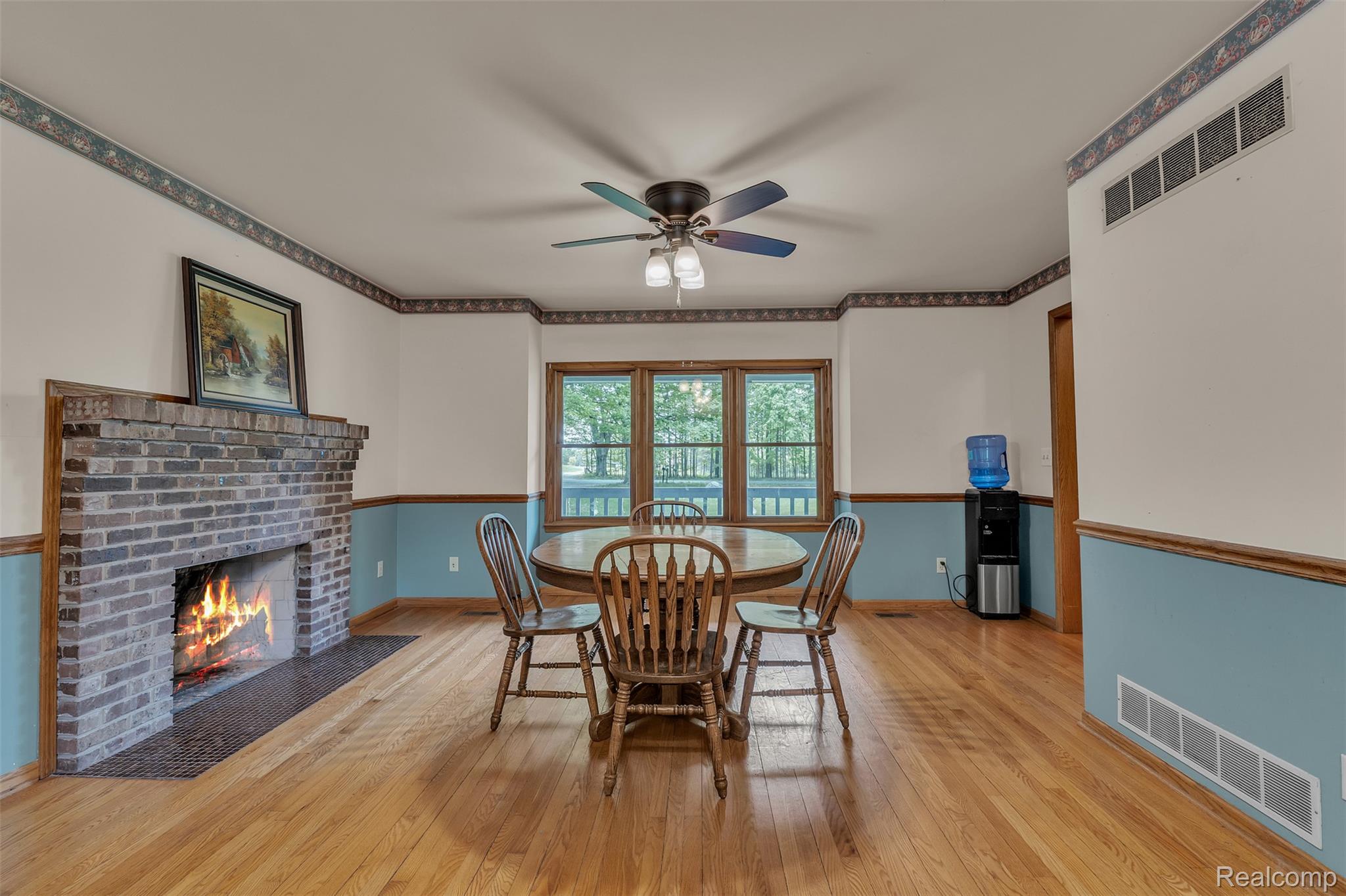1345 Ives Road Mason, MI 48854 - Photo 15 of 92 Dining room featuring a brick fireplace, light wood-type flooring, and ceiling fan