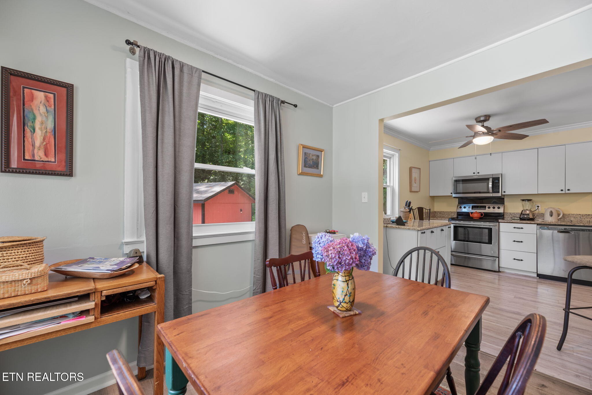 166 Outer Drive Oak Ridge, TN 37830 - Photo 11 of 30 a kitchen with stainless steel appliances kitchen island granite countertop a stove a refrigerator a dining table and chairs with wooden floor