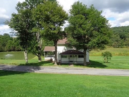 a view of house with outdoor space and swimming pool