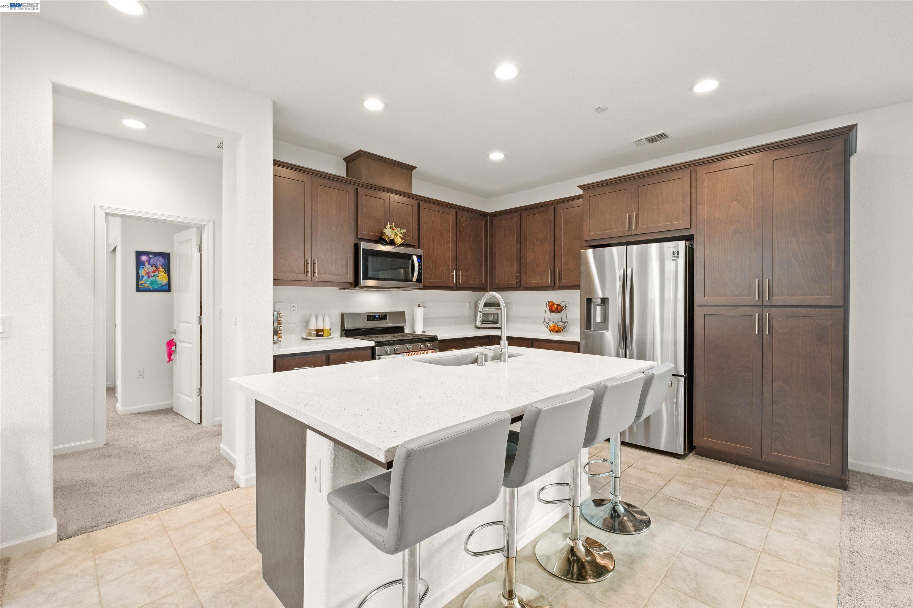 17575 Altair Way Lathrop, CA 95330 - Photo 4 of 29 a kitchen with a refrigerator a stove and a microwave with wooden floor