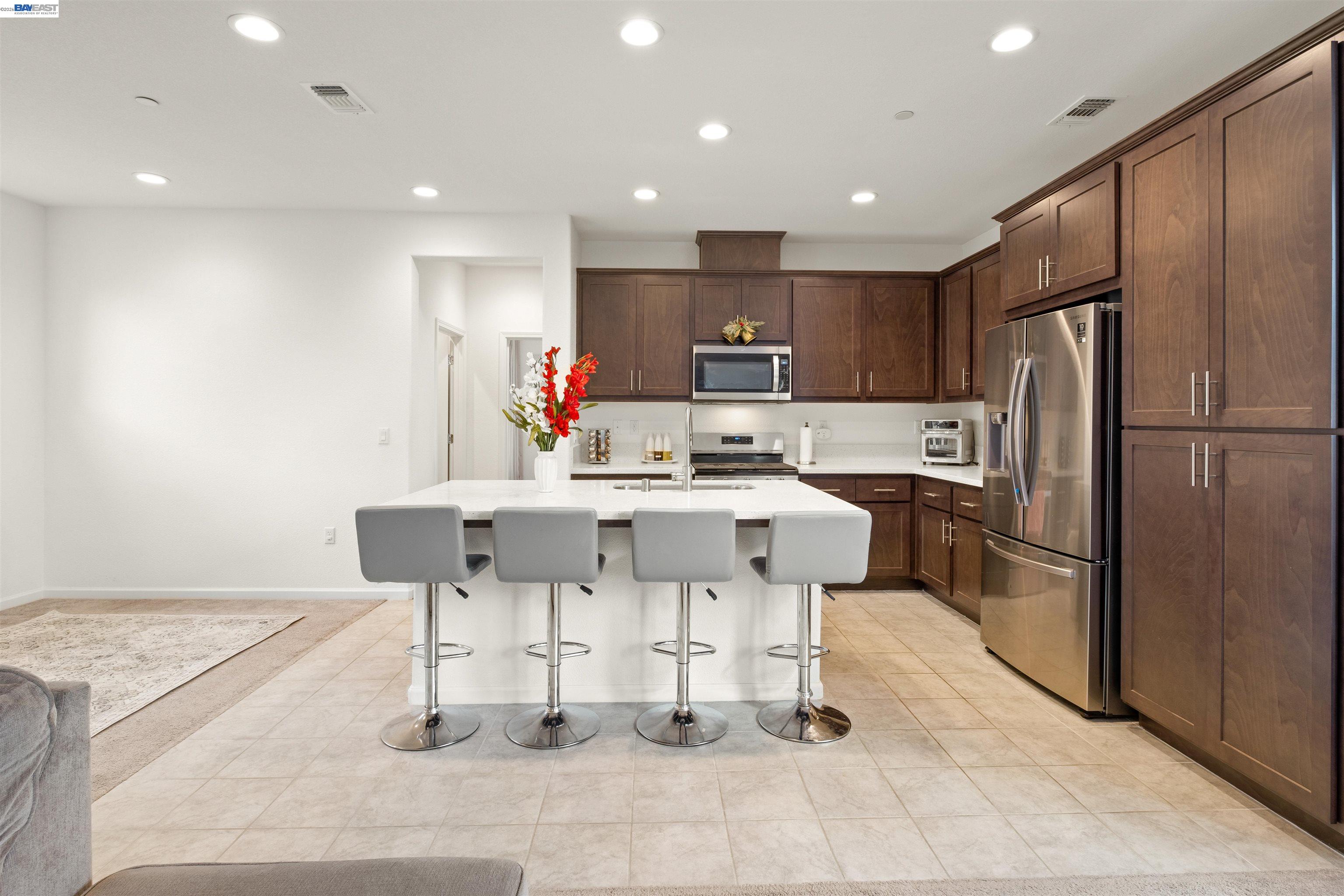 17575 Altair Way Lathrop, CA 95330 - Photo 7 of 29 a kitchen with stainless steel appliances kitchen island granite countertop a refrigerator and a stove top oven