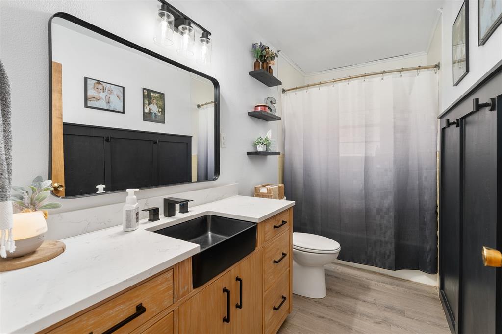 529 East Kempner Street Mabank, TX 75147 - Photo 11 of 16 a bathroom with a sink a toilet and a mirror