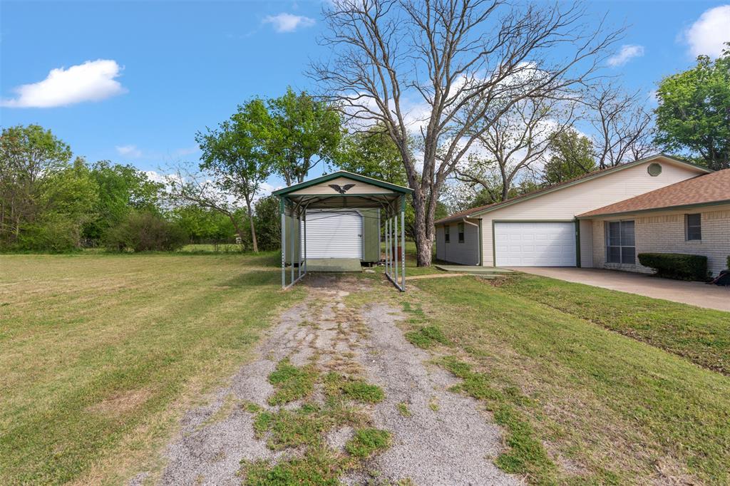 529 East Kempner Street Mabank, TX 75147 - Photo 16 of 16 a front view of a house with a garden and trees