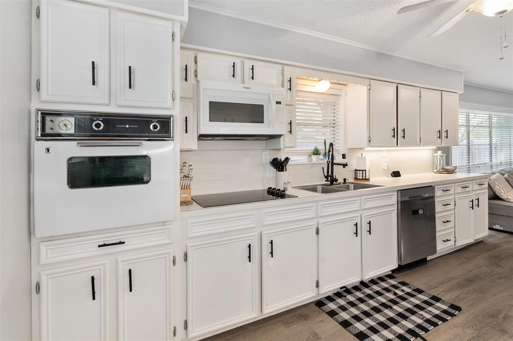 529 East Kempner Street Mabank, TX 75147 - Photo 6 of 16 a kitchen with white cabinets and white appliances