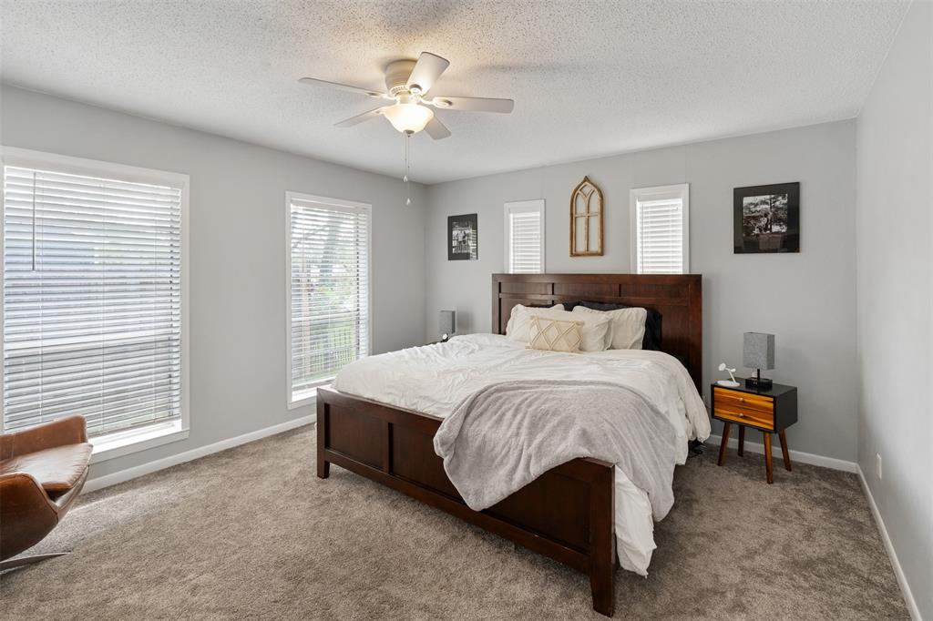 529 East Kempner Street Mabank, TX 75147 - Photo 7 of 16 a spacious bedroom with a bed and a chandelier