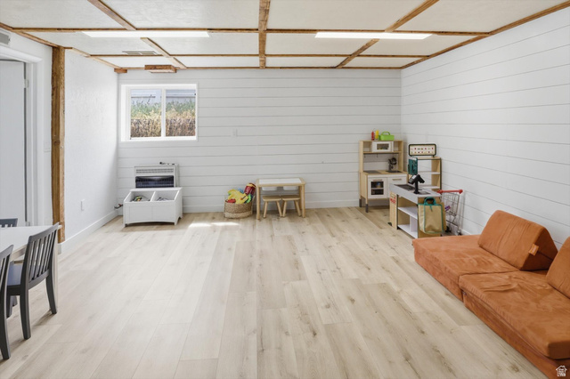 5108 South 2000th Street West Roy, UT 84067 - Photo 32 of 61 Living area featuring light wood-style flooring, wooden walls, and heating unit