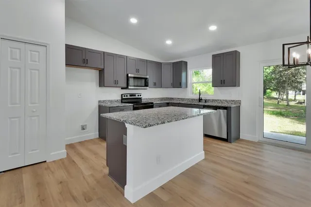 a kitchen with stainless steel appliances granite countertop a stove a sink and a refrigerator