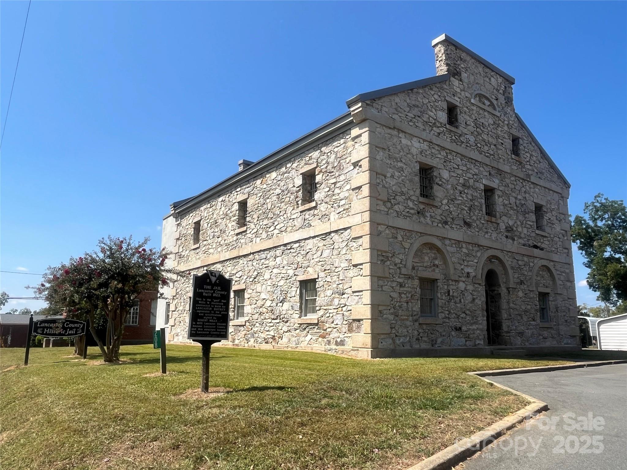 310 Elm Street Lancaster, SC 29720 - Photo 44 of 48 a tall brick building with a yard in front of it