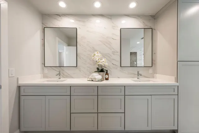 a bathroom with double sink and a mirror
