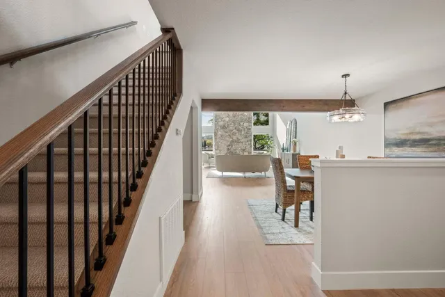 a view of a hallway with wooden floor and dining room