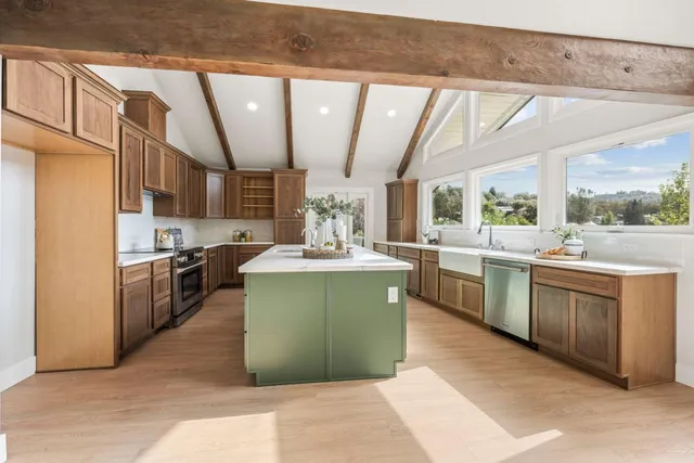 a kitchen with stainless steel appliances granite countertop a sink a stove and a refrigerator