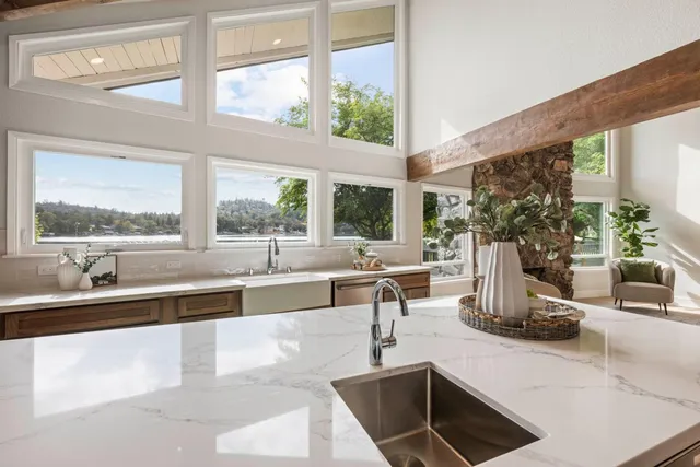 a kitchen with granite countertop a sink and a large window