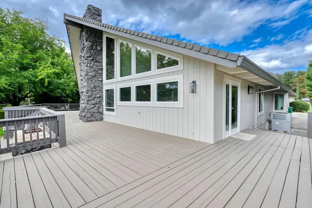 a front view of a house with barbeque oven and seating space