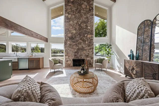 a living room with furniture fireplace and a large window