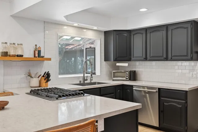 a kitchen with a sink stove top oven and cabinets