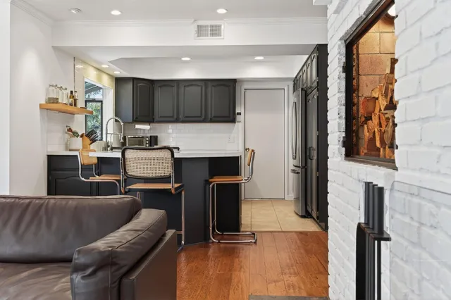 a living room with stainless steel appliances kitchen island granite countertop furniture and a fireplace