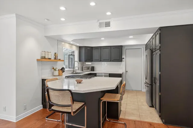 a kitchen with a dining table chairs and refrigerator