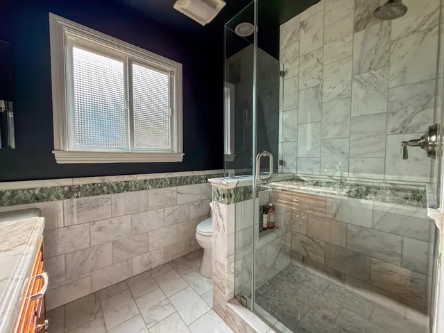 a bathroom with a granite countertop sink a mirror and a bathtub