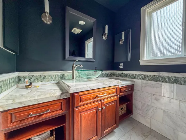 a bathroom with a granite countertop sink and a mirror
