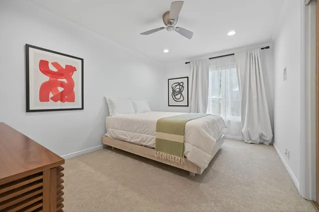 a spacious bedroom with a bed and a painting on the wall
