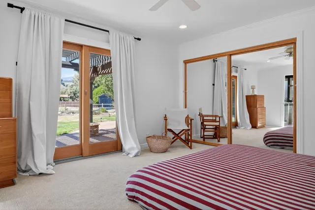 a bedroom with a bed and large windows