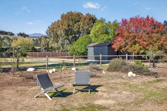 a view of a chairs and table in the backyard