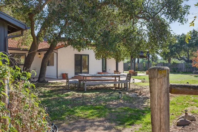 a view of a house with backyard and a tree
