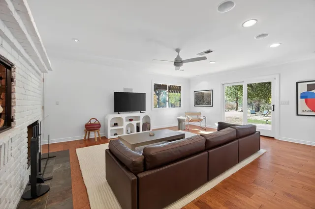 a living room with furniture a flat screen tv and a large window