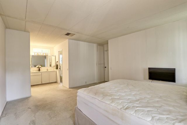 a spacious bedroom with a bed and a view of bathroom