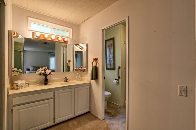 a bathroom with a double vanity sink mirror and toilet