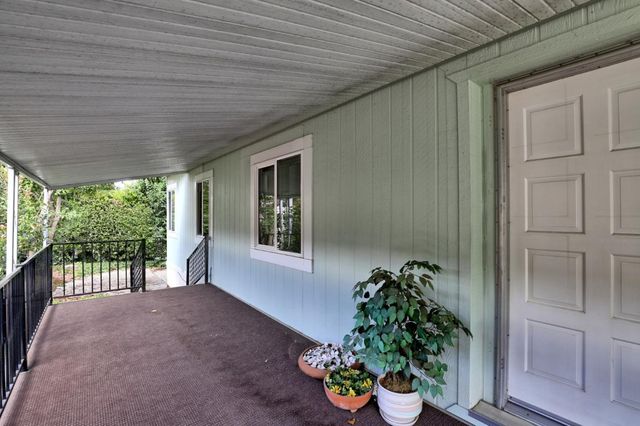 a view of a porch with furniture and garden