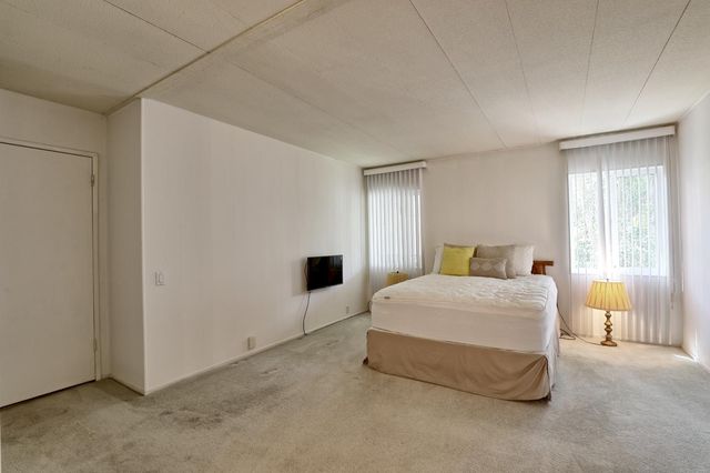 a spacious bedroom with a bed and a window