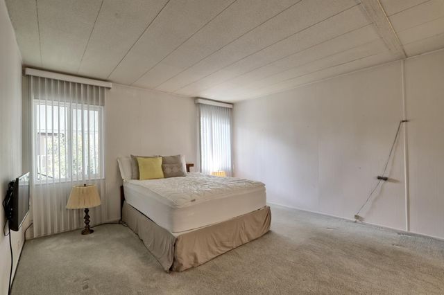 a spacious bedroom with a bed and a window