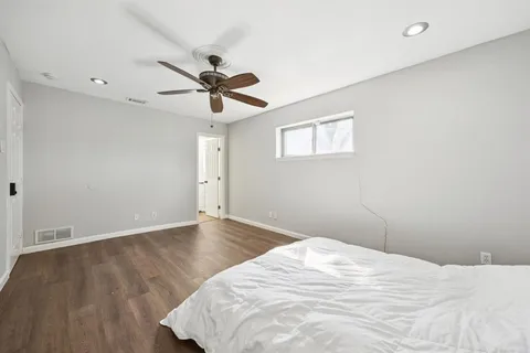 a view of a room with wooden floor and a ceiling fan