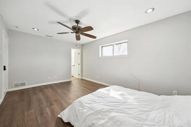 a view of a room with wooden floor and a ceiling fan