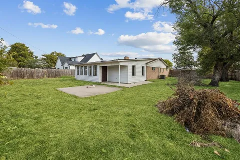 a view of a house with a big yard and large trees