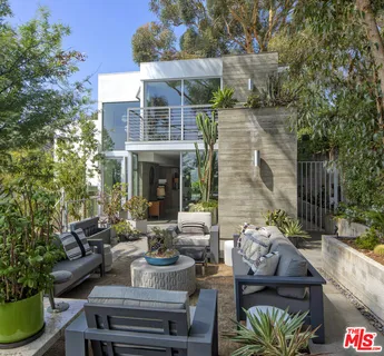 a view of a patio with couches table and chairs and potted plants