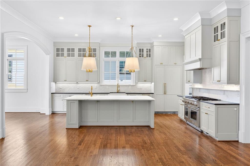 2147 Cooper Lake Road Southeast Smyrna, GA 30080 - Photo 6 of 65 a kitchen with stainless steel appliances granite countertop a stove a sink and white cabinets with wooden floor