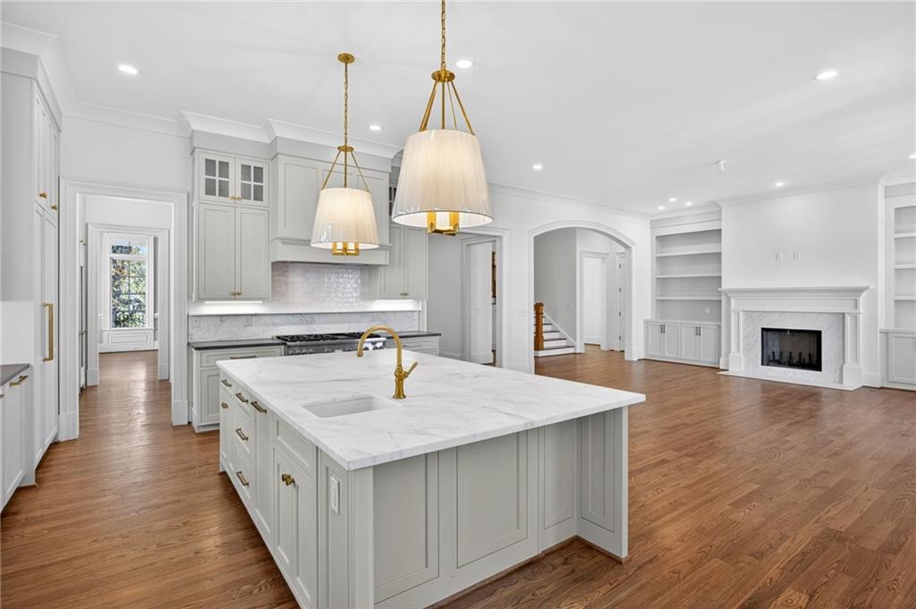 2147 Cooper Lake Road Southeast Smyrna, GA 30080 - Photo 7 of 65 a large kitchen with kitchen island a stove a sink a center island and wooden floor