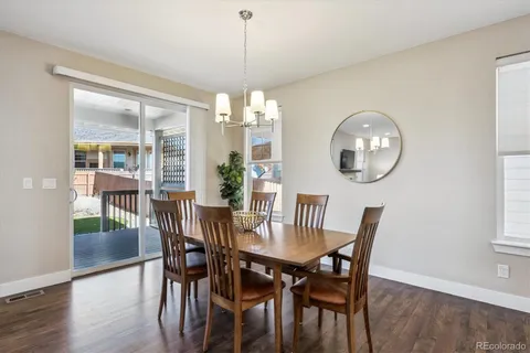 a view of a dining room with furniture a chandelier and wooden floor