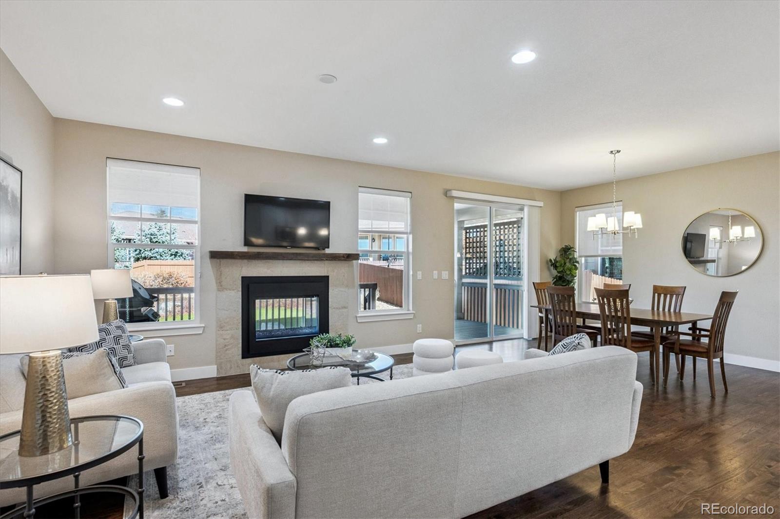 6667 Club Villa Road Parker, CO 80134 - Photo 2 of 50 a living room with furniture a fireplace and a large window