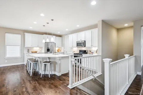 a kitchen with kitchen island granite countertop a stove and a wooden floors