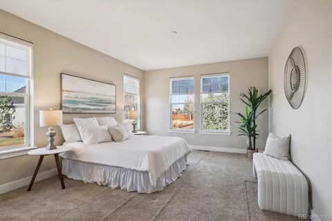 a spacious bedroom with a large bed and a chandelier