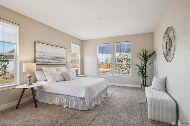 a spacious bedroom with a large bed and a chandelier