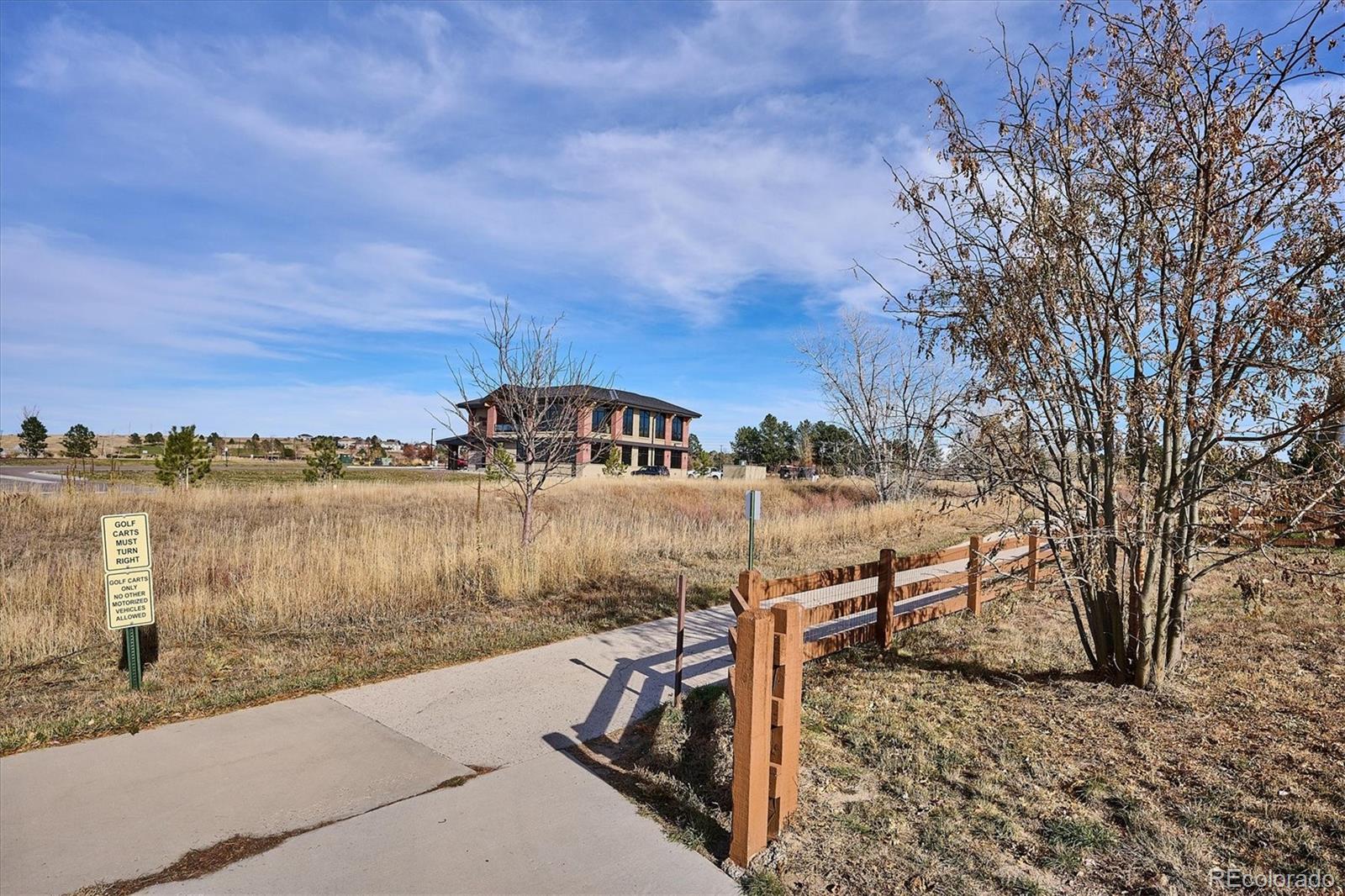 6667 Club Villa Road Parker, CO 80134 - Photo 49 of 50 a view of a lake with a bench in front of house
