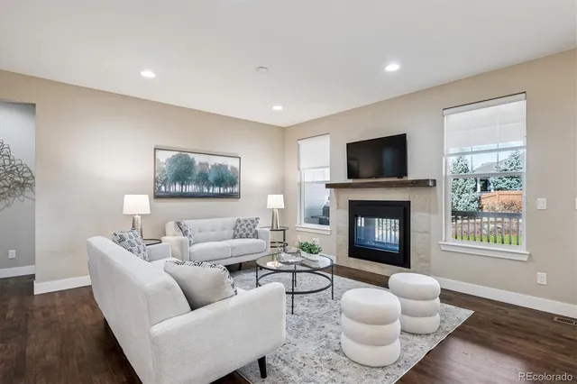 a living room with furniture a fireplace and a flat screen tv