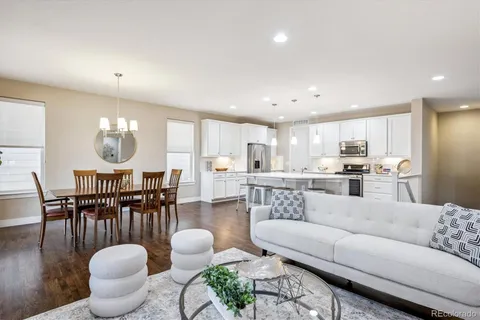 a living room with furniture a rug and kitchen view