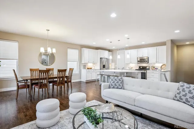 a living room with furniture a rug and kitchen view